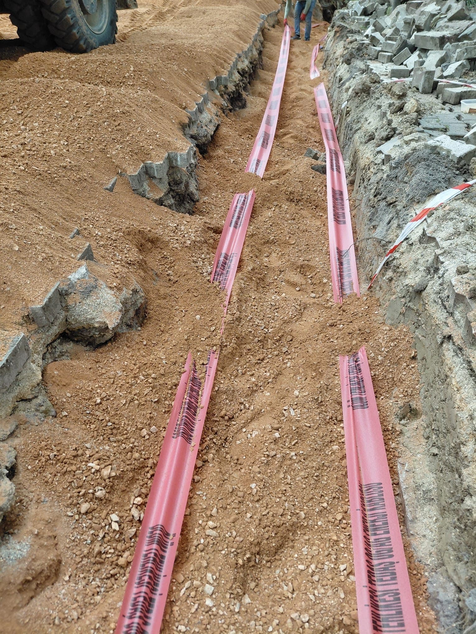 Açılan kanala döşenmiş kırmızı HDPE enerji boruları ve ihbar bandı