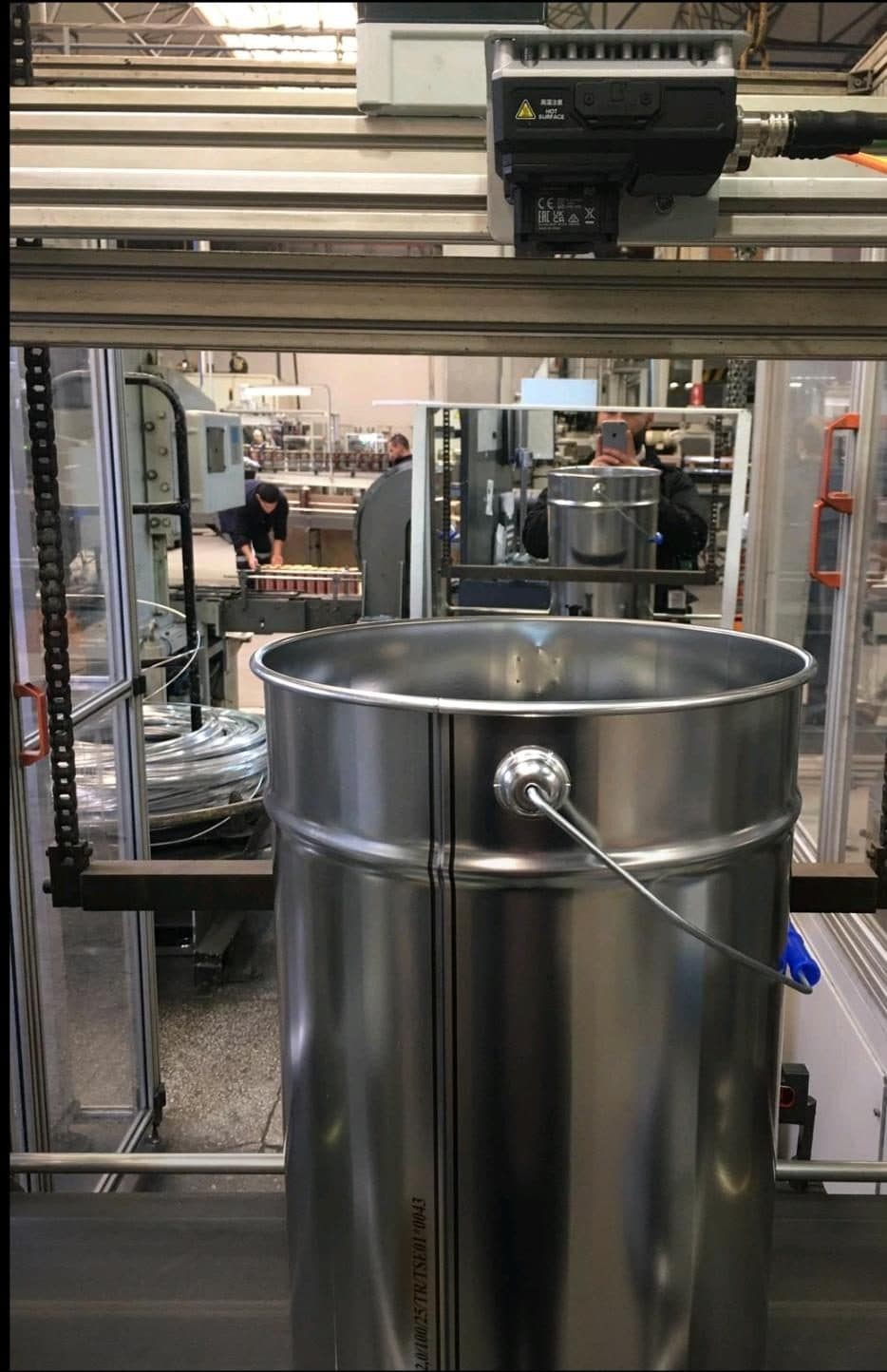 Teneke üretim hattı üzerindeki kamera düzeneği ve kontrol edilen metal kova