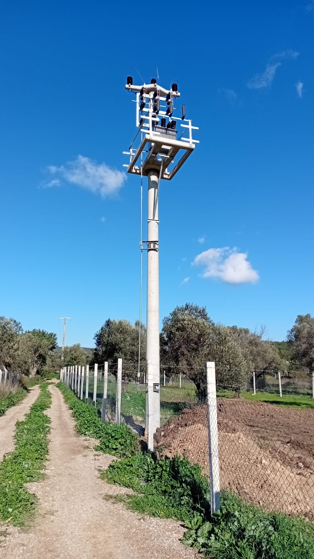 Montajı tamamlanmış direk üzerindeki travers, izolatörler ve 34,5 kV iletken bağlantıları